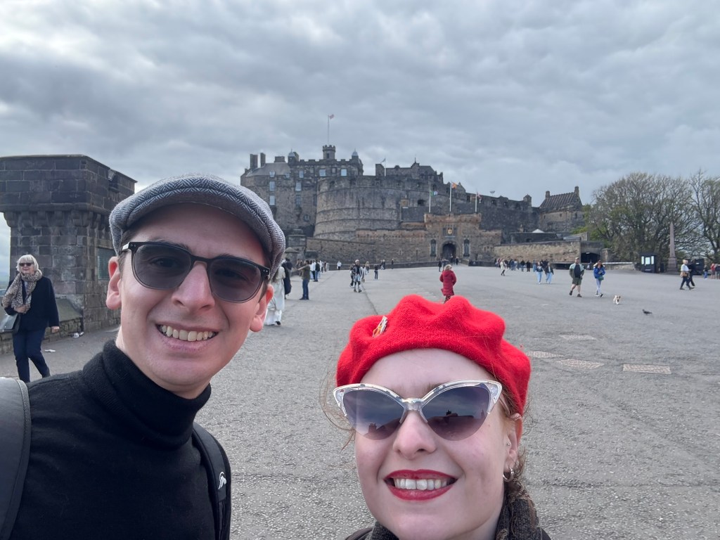 Two people take a selfie in front of Edinburgh Castle
