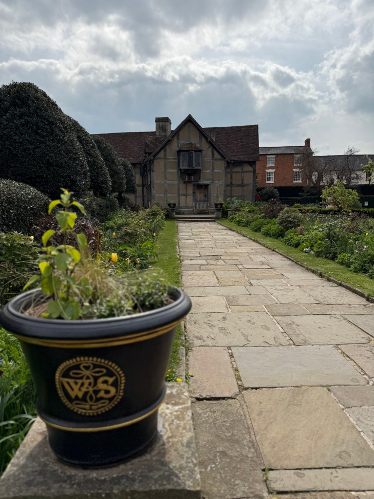 A garden with a path leading to an old style country house