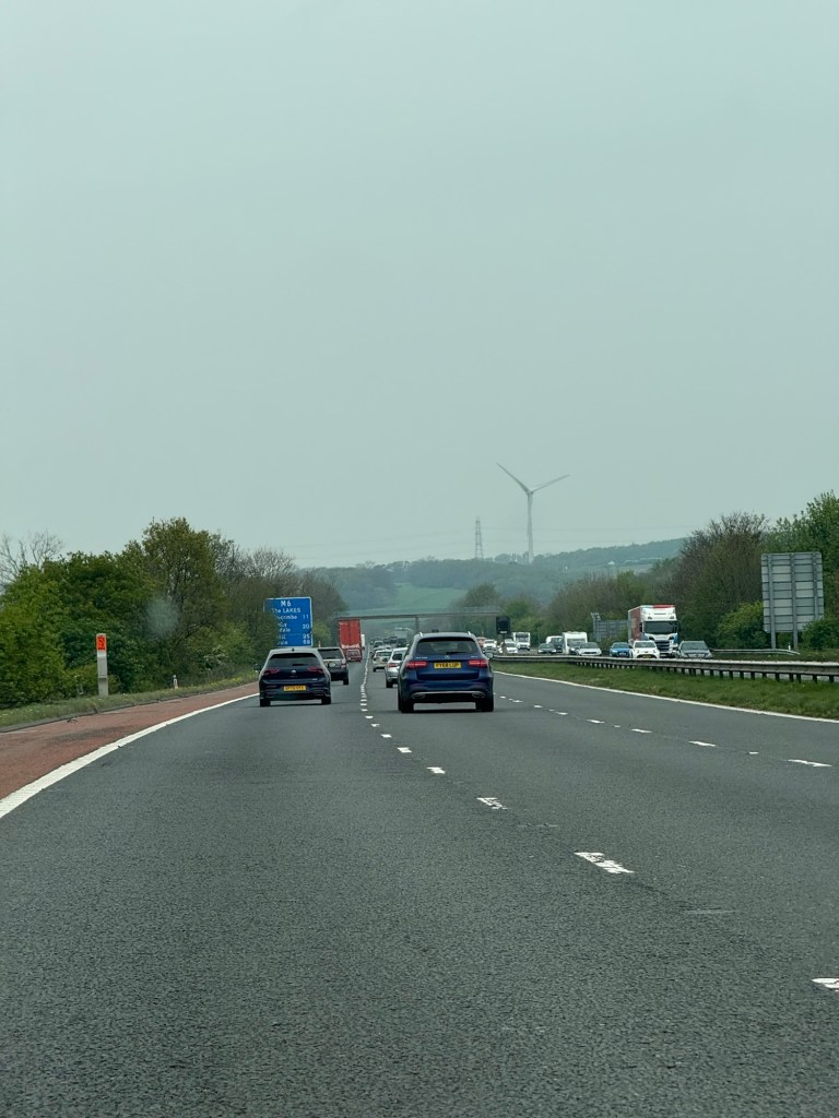 View of the motorway with huge wind turnbines in the background