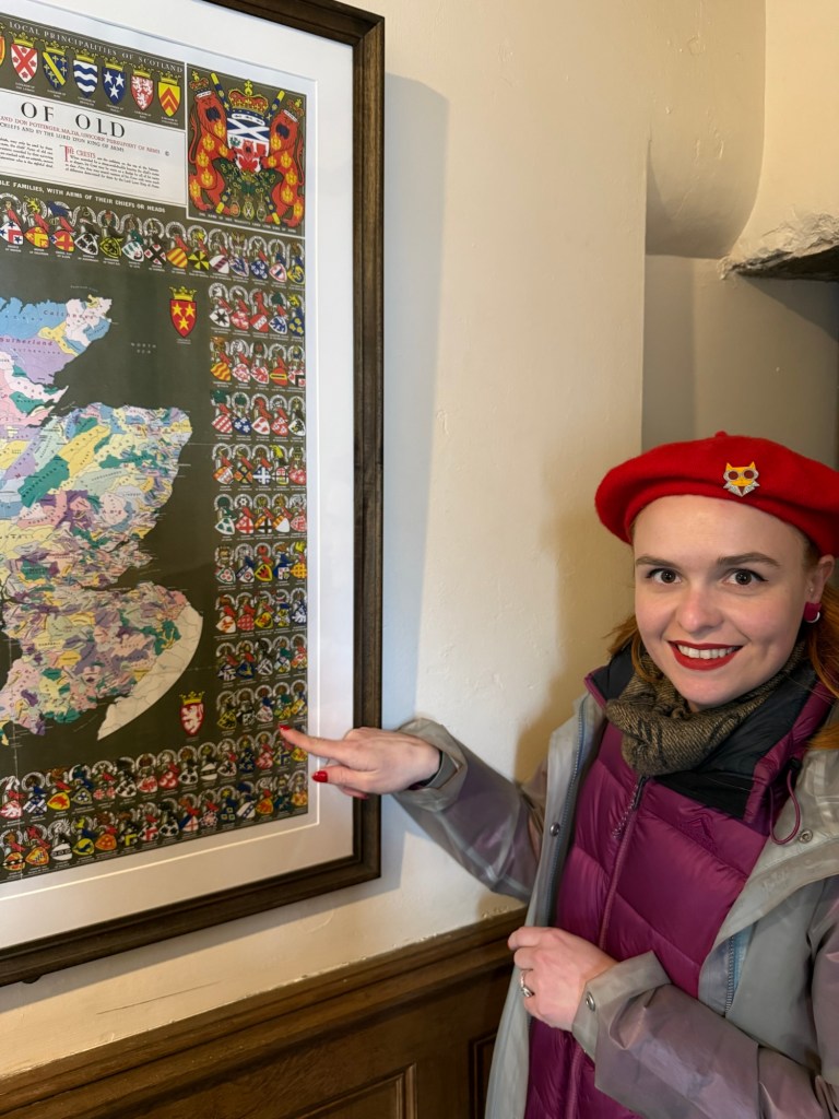 A woman excitedly points to her clan coat of arms