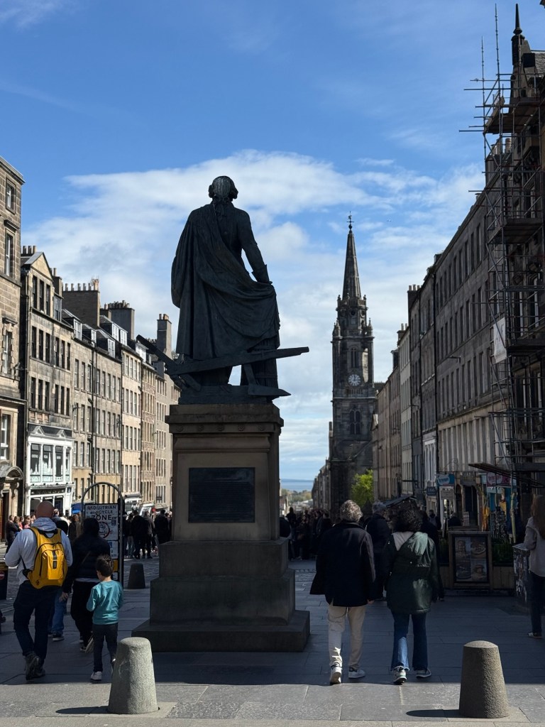 The back of a statue showing the Royal Mile in Edinburgh