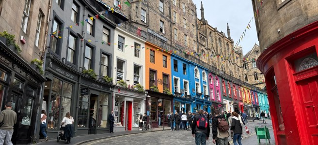 Different coloured 18th century shop fronts along a curved cobblestone street